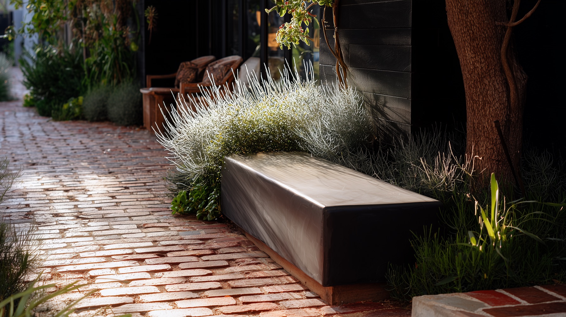 Refined architectural concrete seat beside brick paving and garden planting