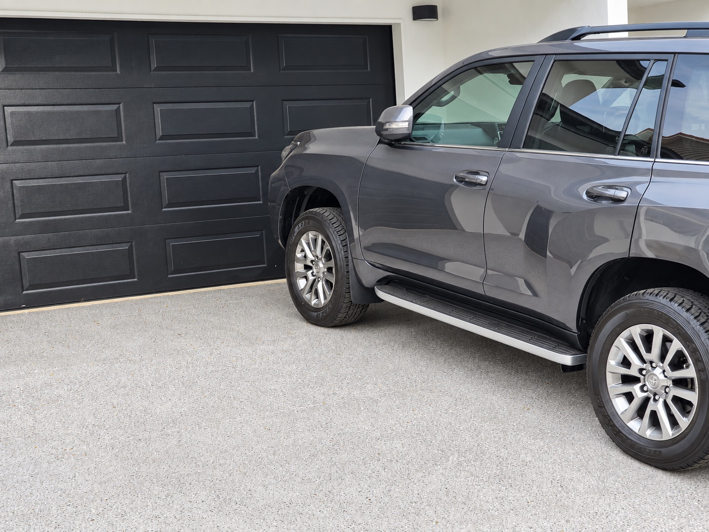 Completed spray-finished Brisbane driveway with a parked four-wheel drive